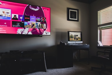 black flat screen tv turned on near black wooden table