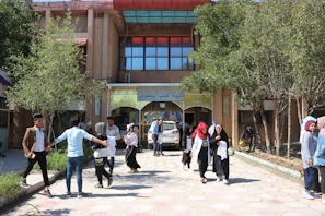 A community center bustling with Afghan citizens receiving government services with smiling staff