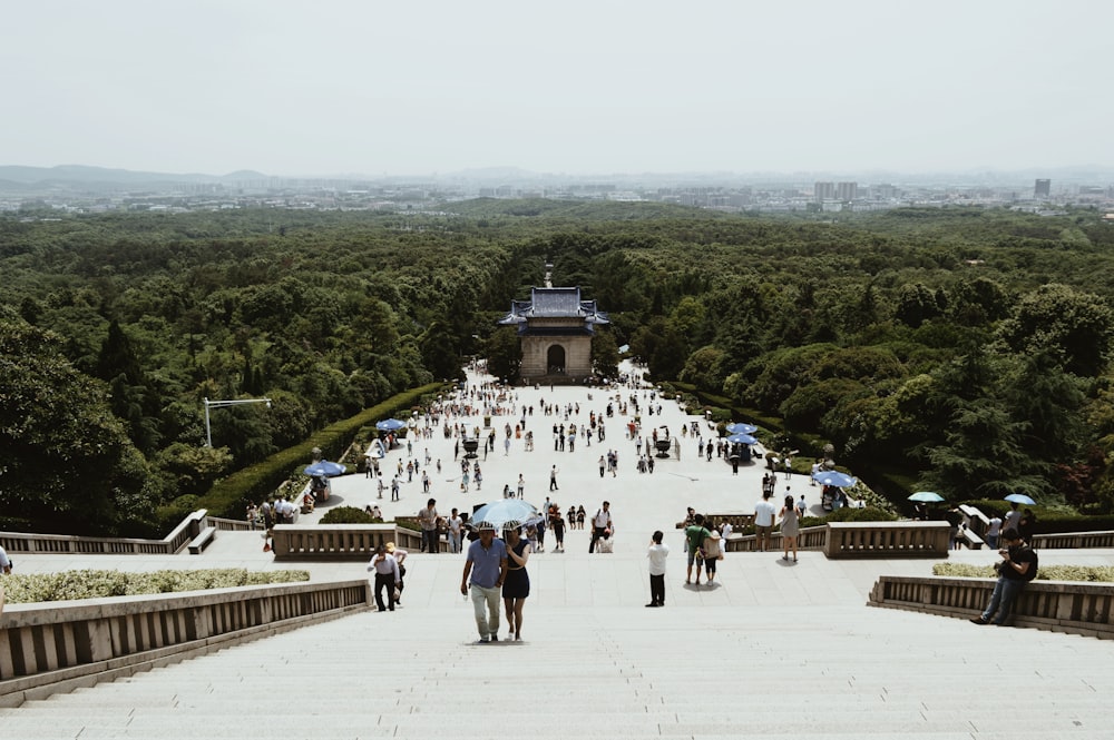 a group of people walking up a hill with umbrellas