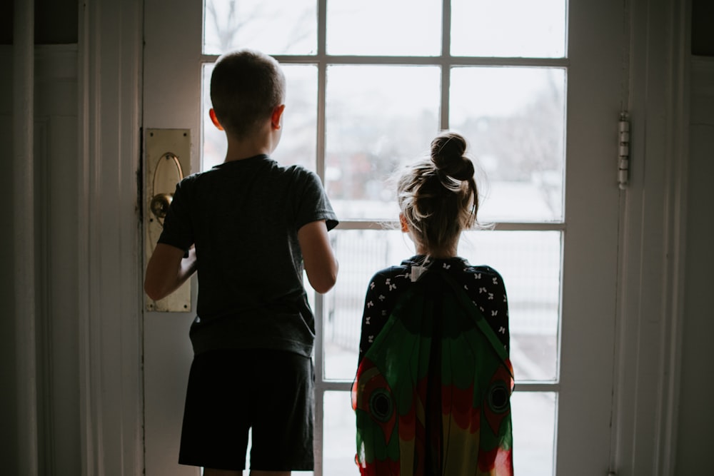 homme en t-shirt à col rond noir debout à côté d’une femme en robe verte et orange