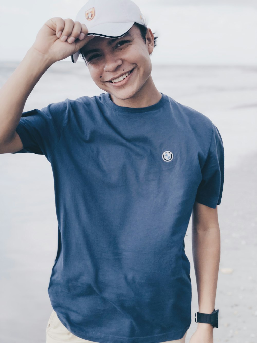 man in blue crew neck t-shirt standing on beach during daytime