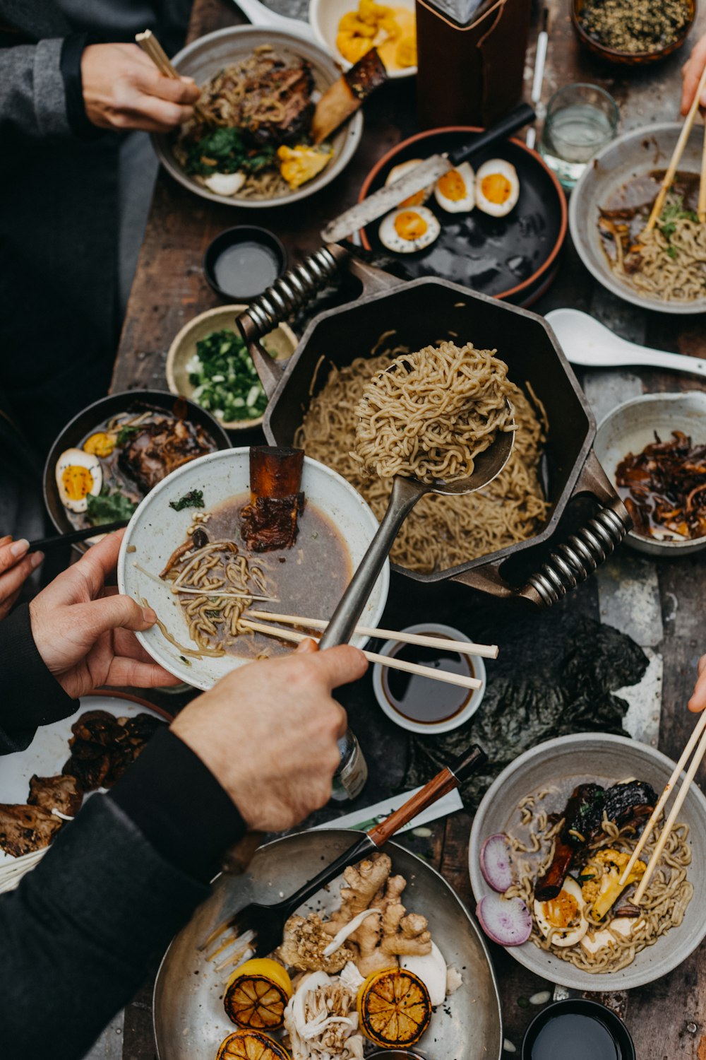 person holding white ceramic bowl with noodles