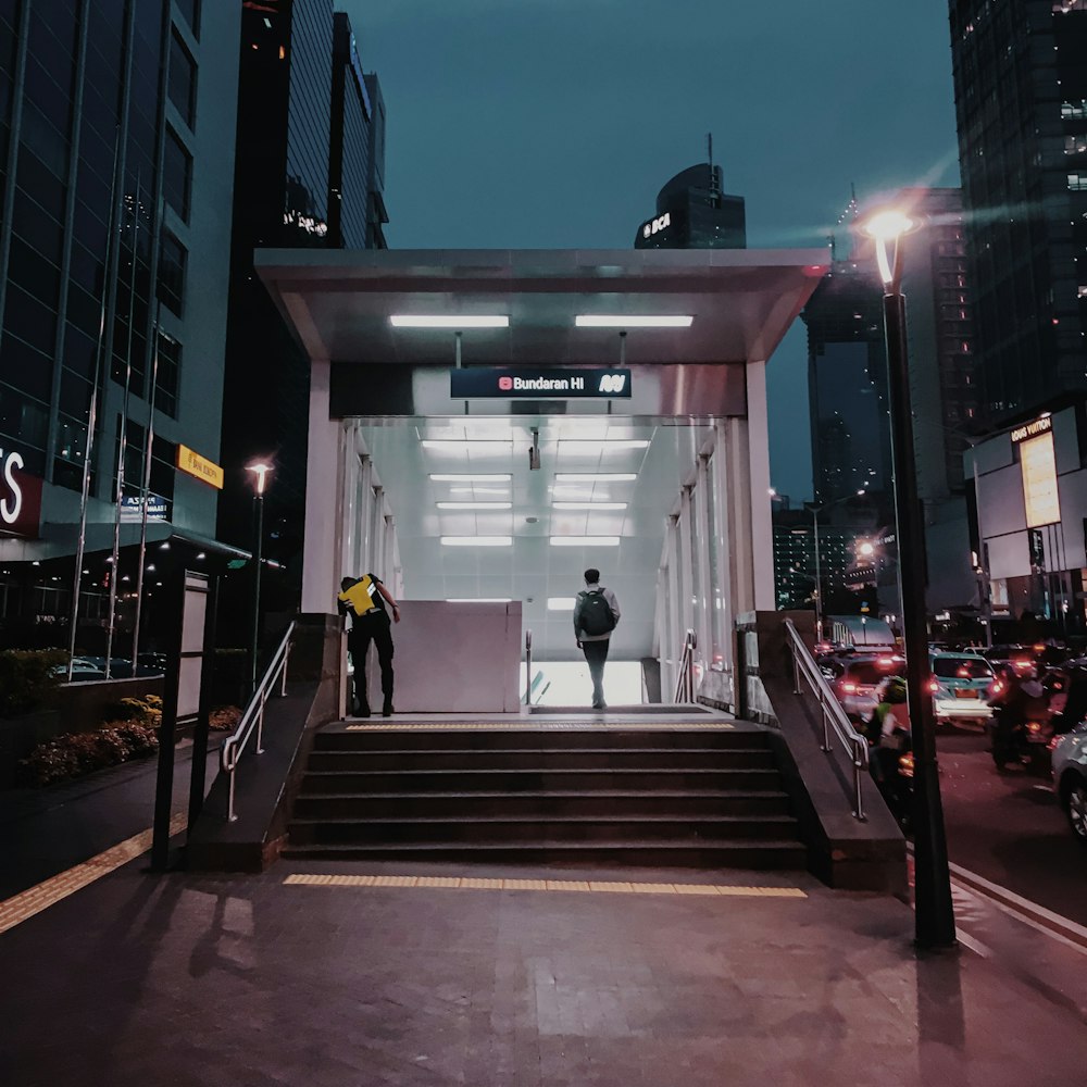 people walking on sidewalk during night time