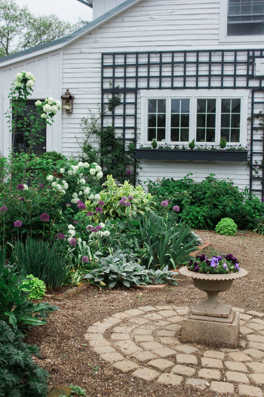 A white house with tidy flower beds along the front walk.