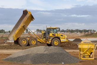 yellow and black heavy equipment on brown dirt field during daytime