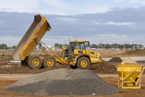 yellow and black heavy equipment on brown dirt field during daytime