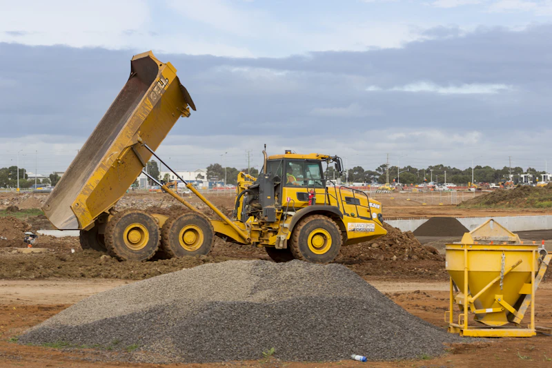 articulated dump truck tipping gravel on site