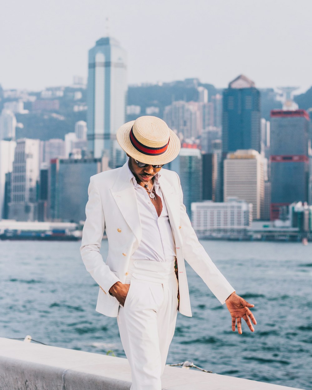 woman in white coat and white hat standing on dock during daytime