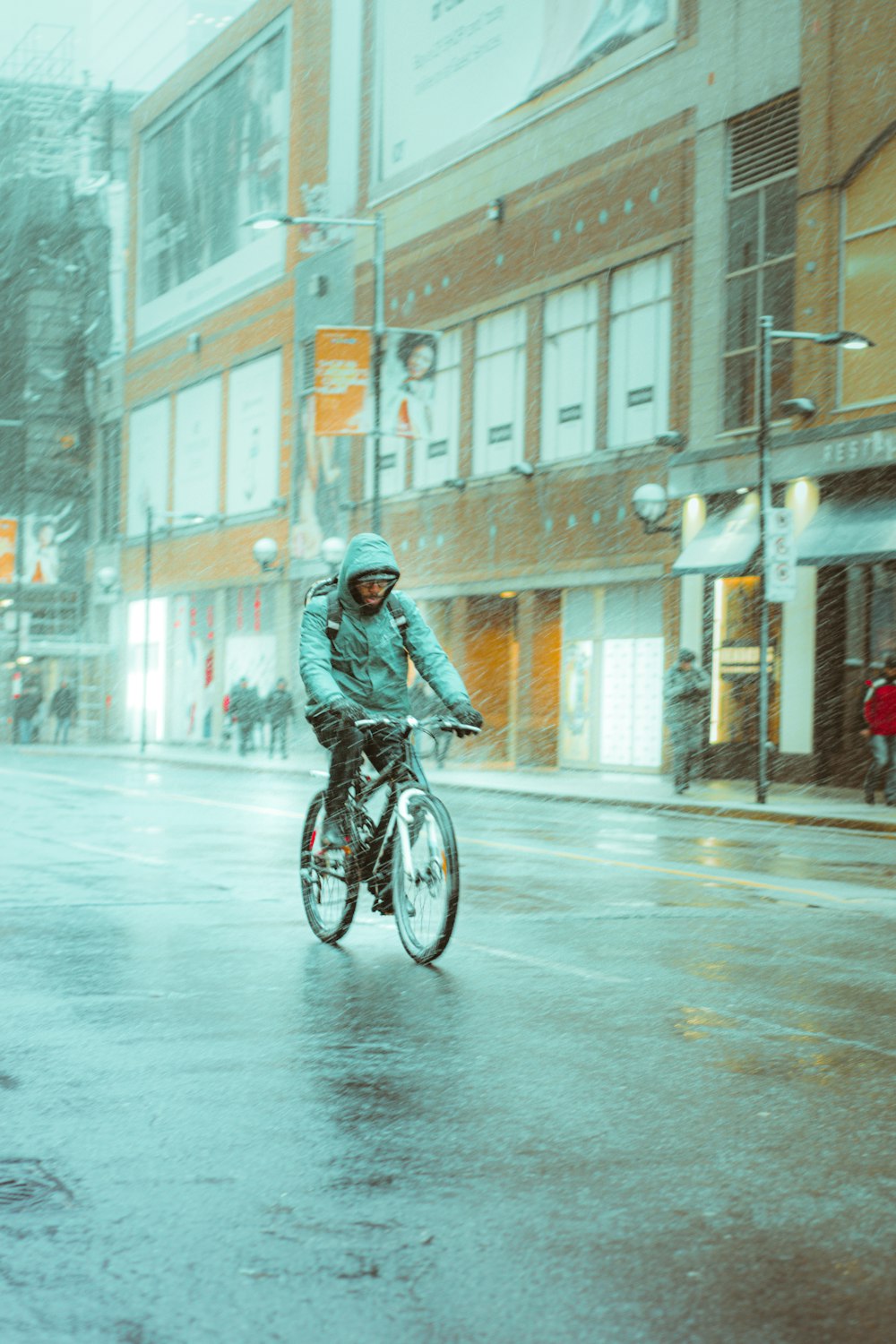 man in black jacket riding bicycle on road during daytime