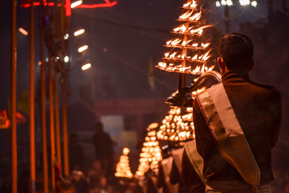 homme en veste marron debout près d’une lampe blanche et brune