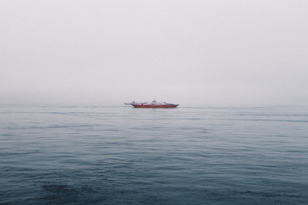 昼間の海上の赤いボート