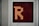 A digital display panel features a large orange letter 'R' made up of illuminated dots against a dark background. The panel is bordered by a metallic frame.