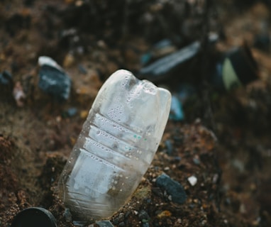 white plastic bottle on brown soil