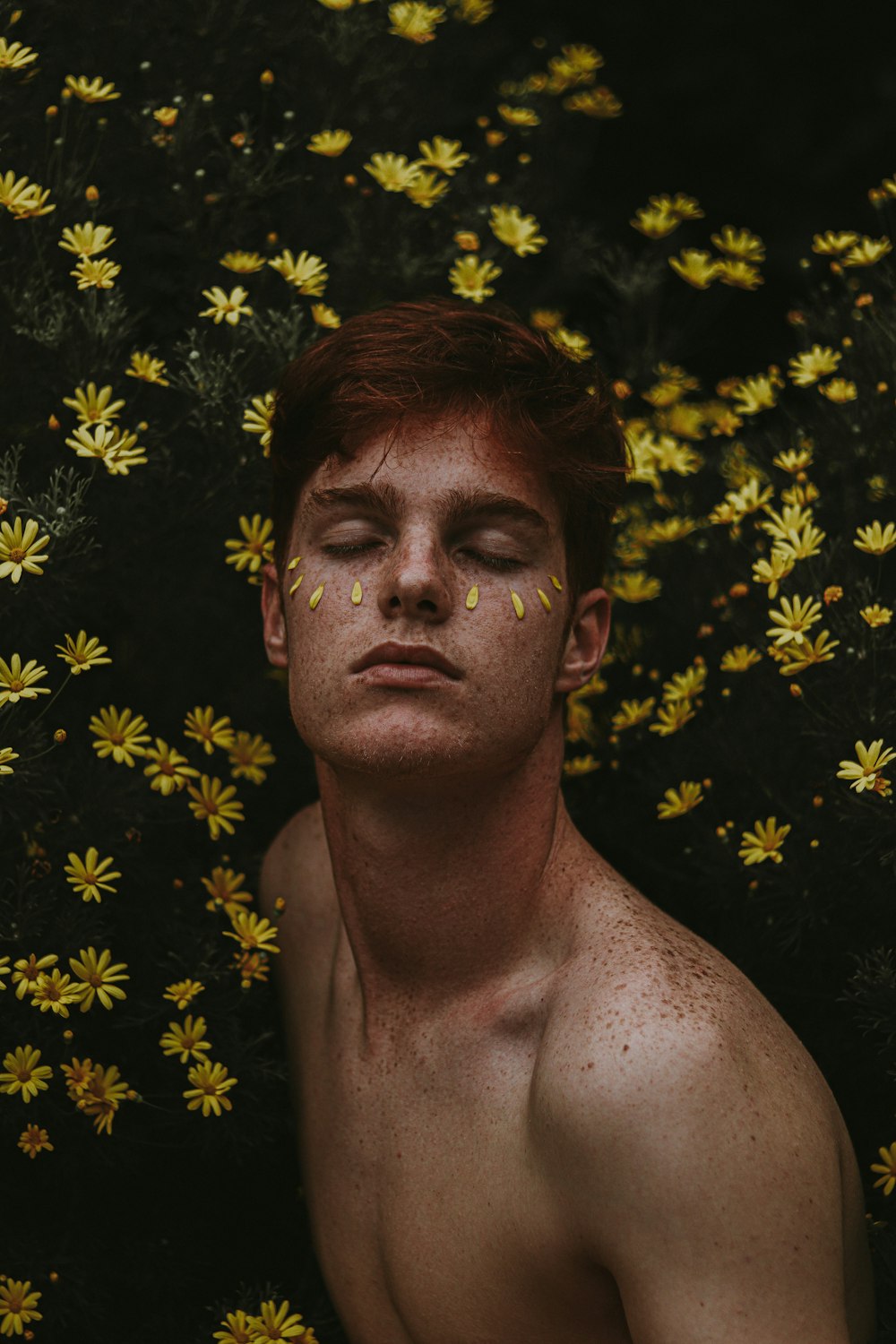 topless man near yellow leaves