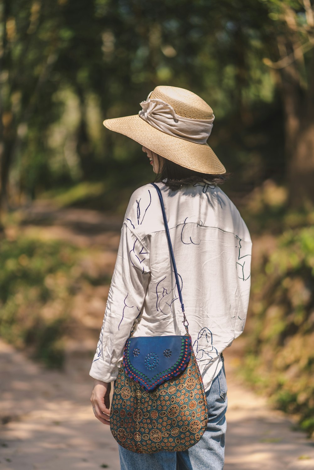 woman in white jacket wearing brown fedora hat