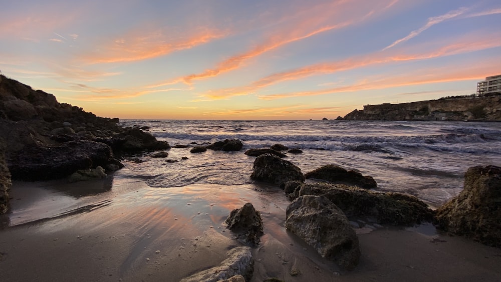 sea waves crashing on shore during sunset