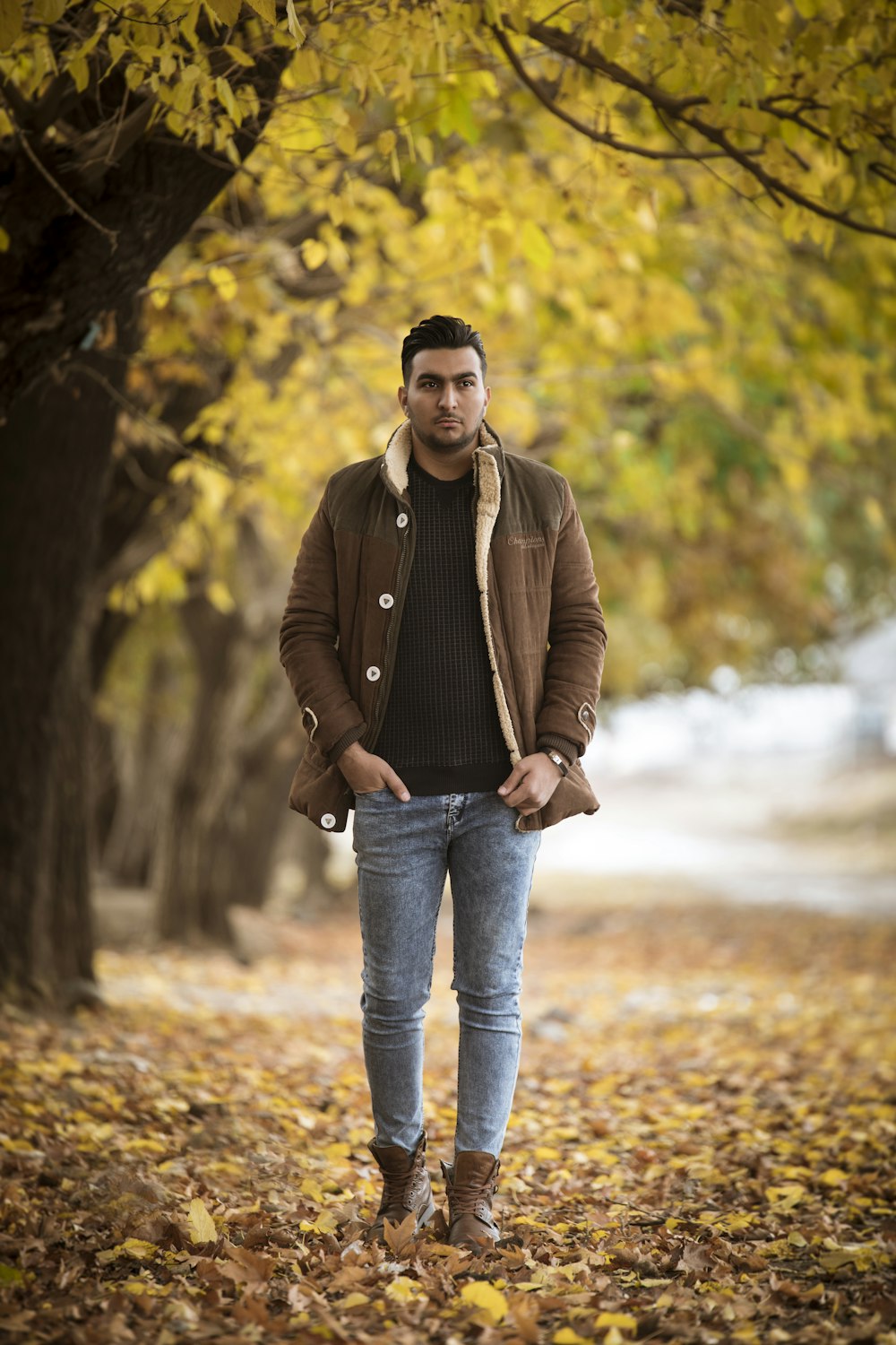 man in brown leather jacket and blue denim jeans standing on brown dirt  road during daytime photo – Free Iranian Image on Unsplash