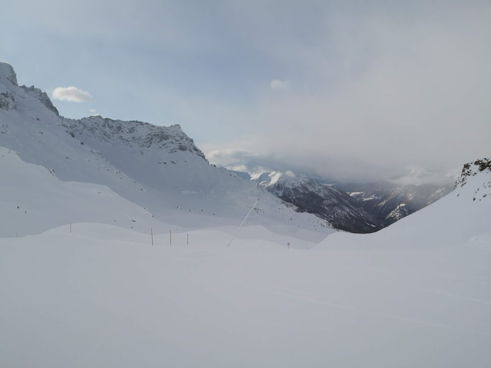 Schneebedeckte Berge unter weißem, bewölktem Himmel tagsüber