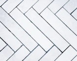 Sleek modern grey ceramic tiles arranged in a herringbone pattern.