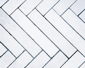 Sleek modern grey ceramic tiles arranged in a herringbone pattern.