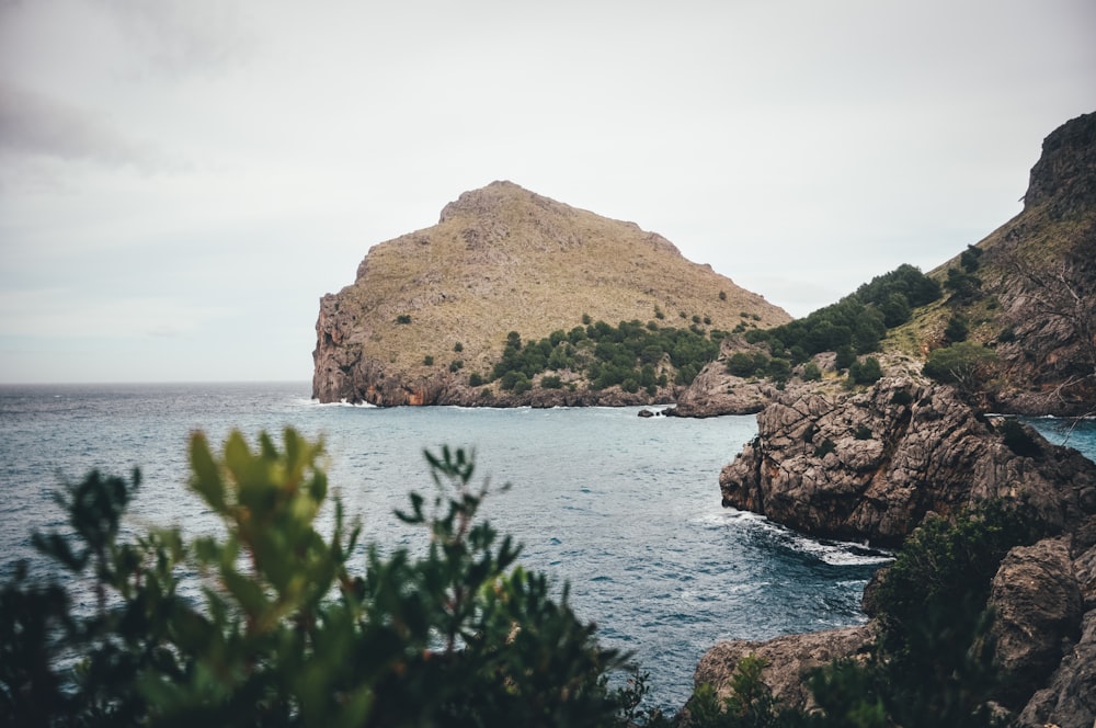 brown rock formation on body of water during daytime