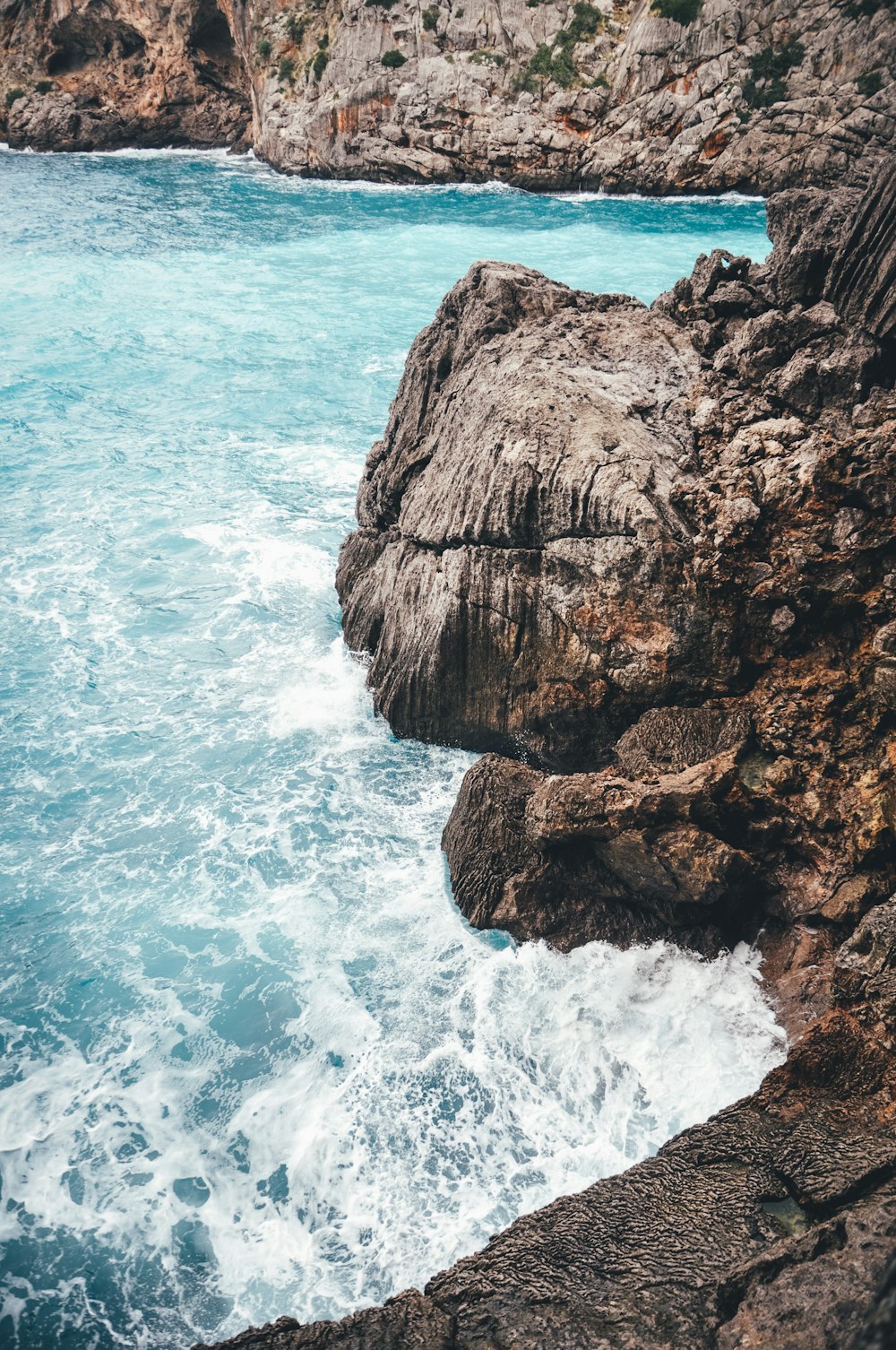 brown rock formation on body of water during daytime