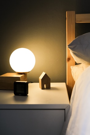 A cozy bedroom scene with soft lighting highlighting a clock showing 10pm and a bedside table with magnesium supplements.