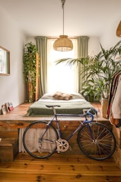 An airy bedroom with light fabrics and plants placed near natural light.