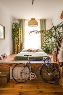 An airy bedroom with light fabrics and plants placed near natural light.