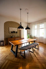 Contemporary dining room with engineered reclaimed wood flooring and subtle gold accents in lighting fixtures.