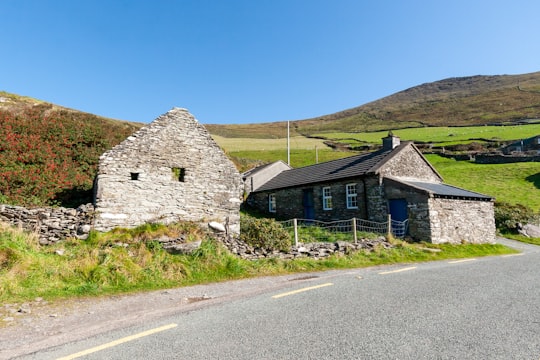gray concrete house near road under blue sky during daytime in County Kerry Ireland