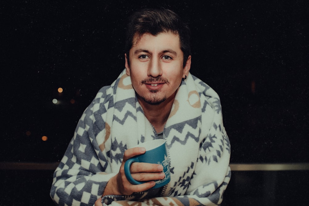 man in blue and white checkered dress shirt holding blue ceramic mug