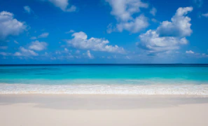 A serene beach scene on Boracay with powdery white sand and turquoise waves under a clear blue sky