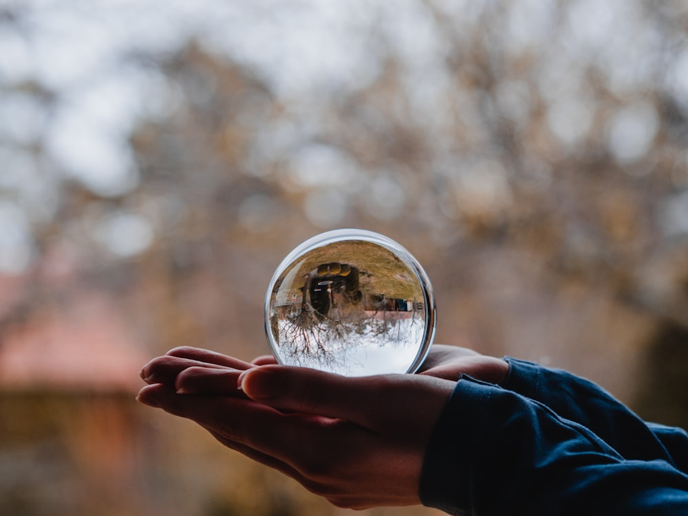 person holding round mirror with bokeh lights
