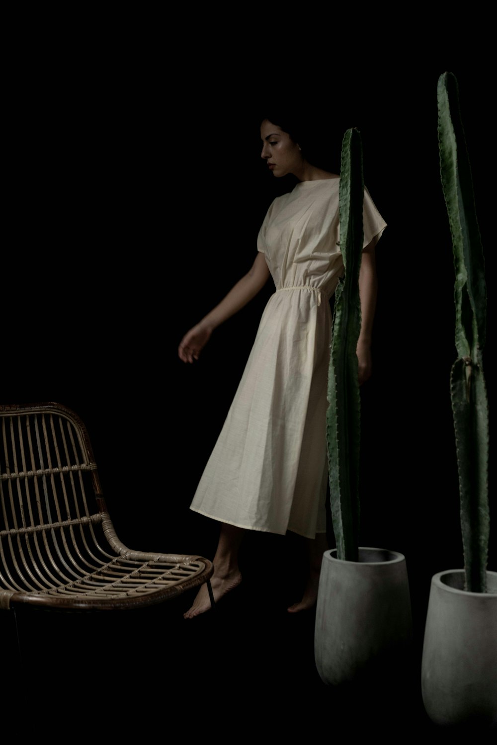 woman in white dress standing beside green curtain