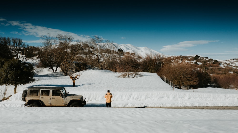 person in yellow jacket standing on snow covered ground during daytime