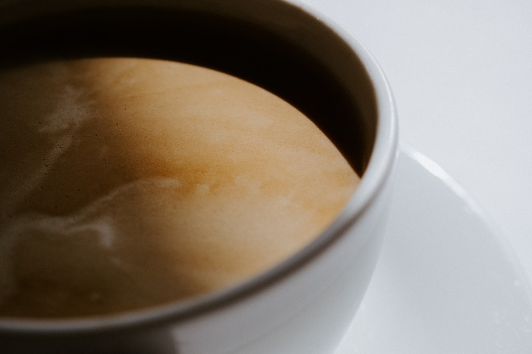 white ceramic mug with brown liquid