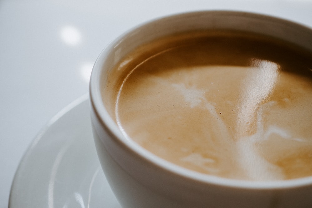 taza de cerámica blanca con líquido marrón