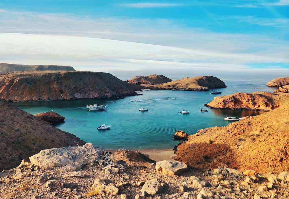 formação rochosa marrom e verde no mar azul sob o céu azul durante o dia