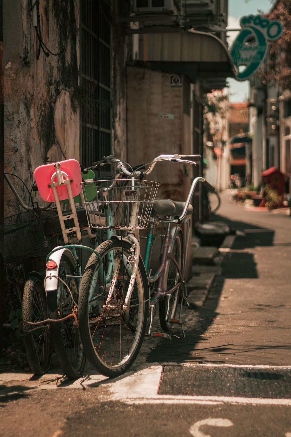 red city bike parked beside brown concrete wall during daytime