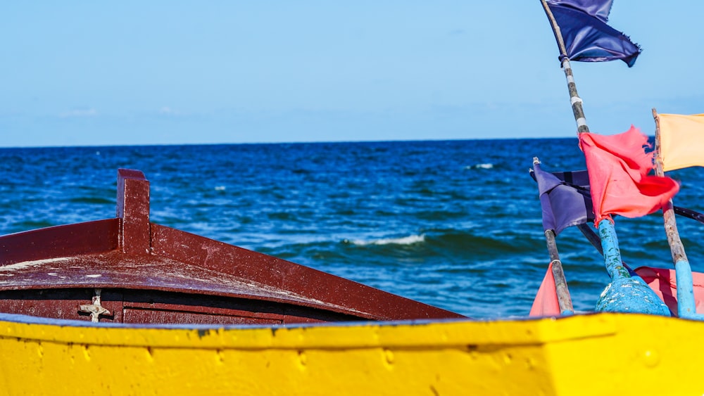 Gelbes und rotes Boot tagsüber auf See
