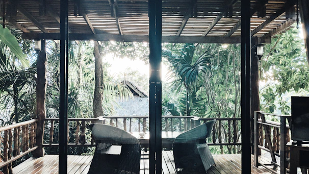 Guests enjoying a peaceful morning on the porch surrounded by lush greenery.