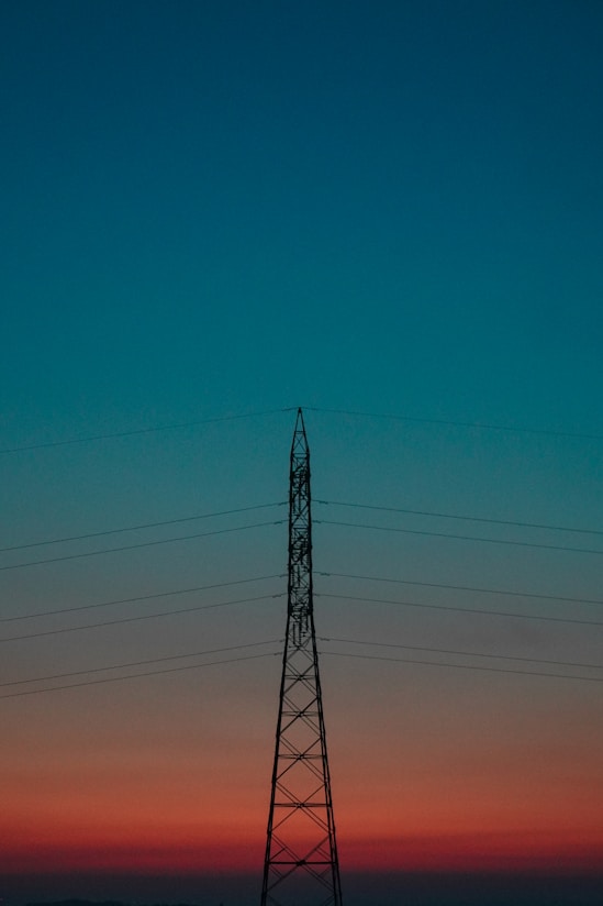 black electric tower under blue sky during daytime