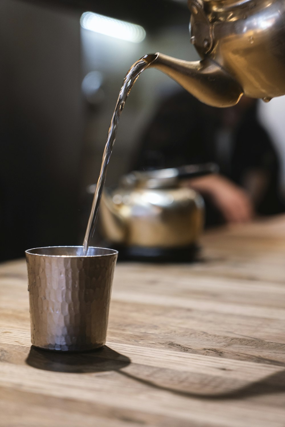 person pouring water on stainless steel cup