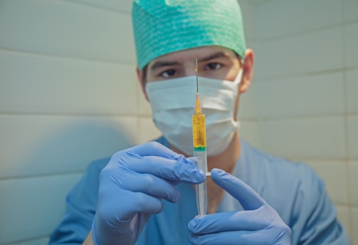 person in blue knit cap holding clear glass tube