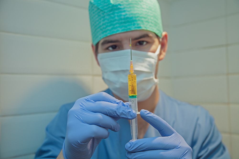 person in blue knit cap holding clear glass tube