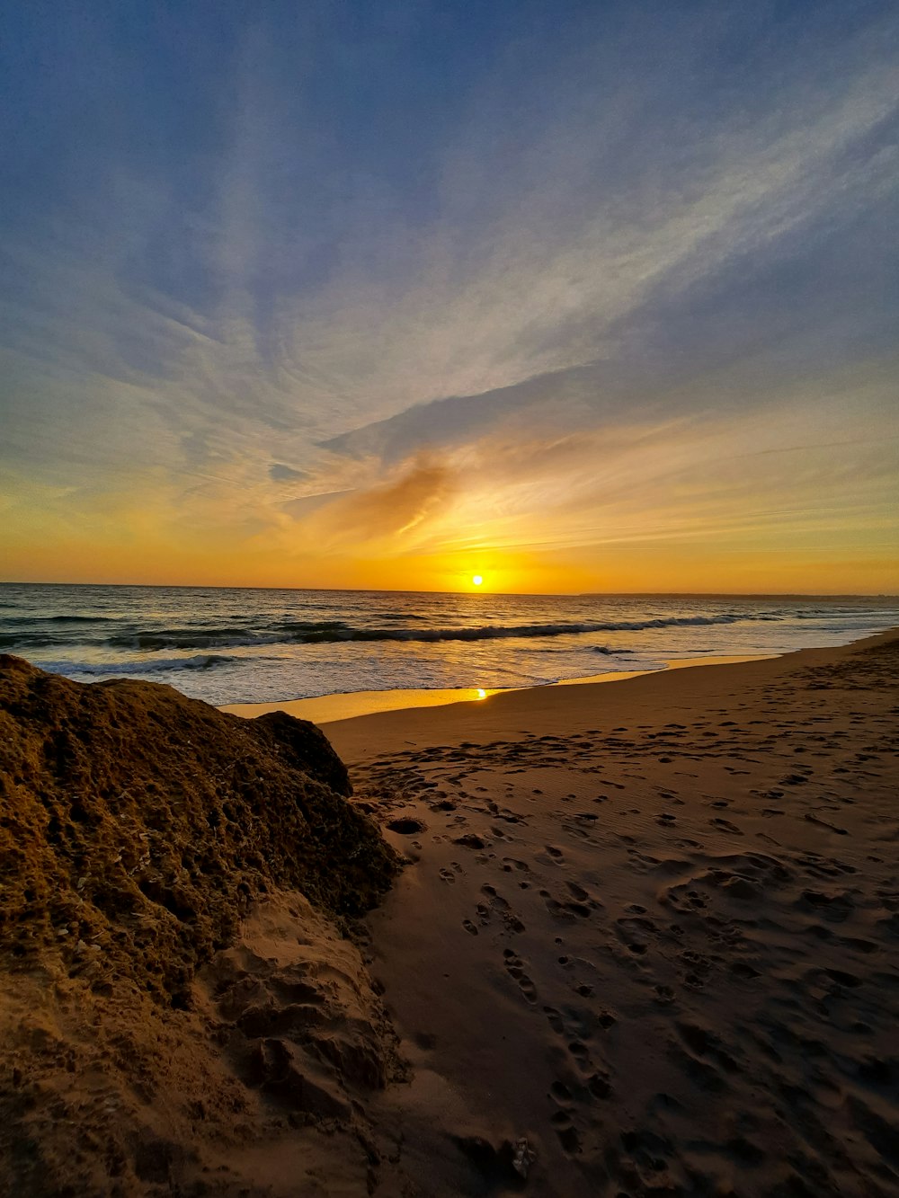 sea waves crashing on shore during sunset