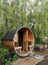 brown wooden shed near green trees during daytime