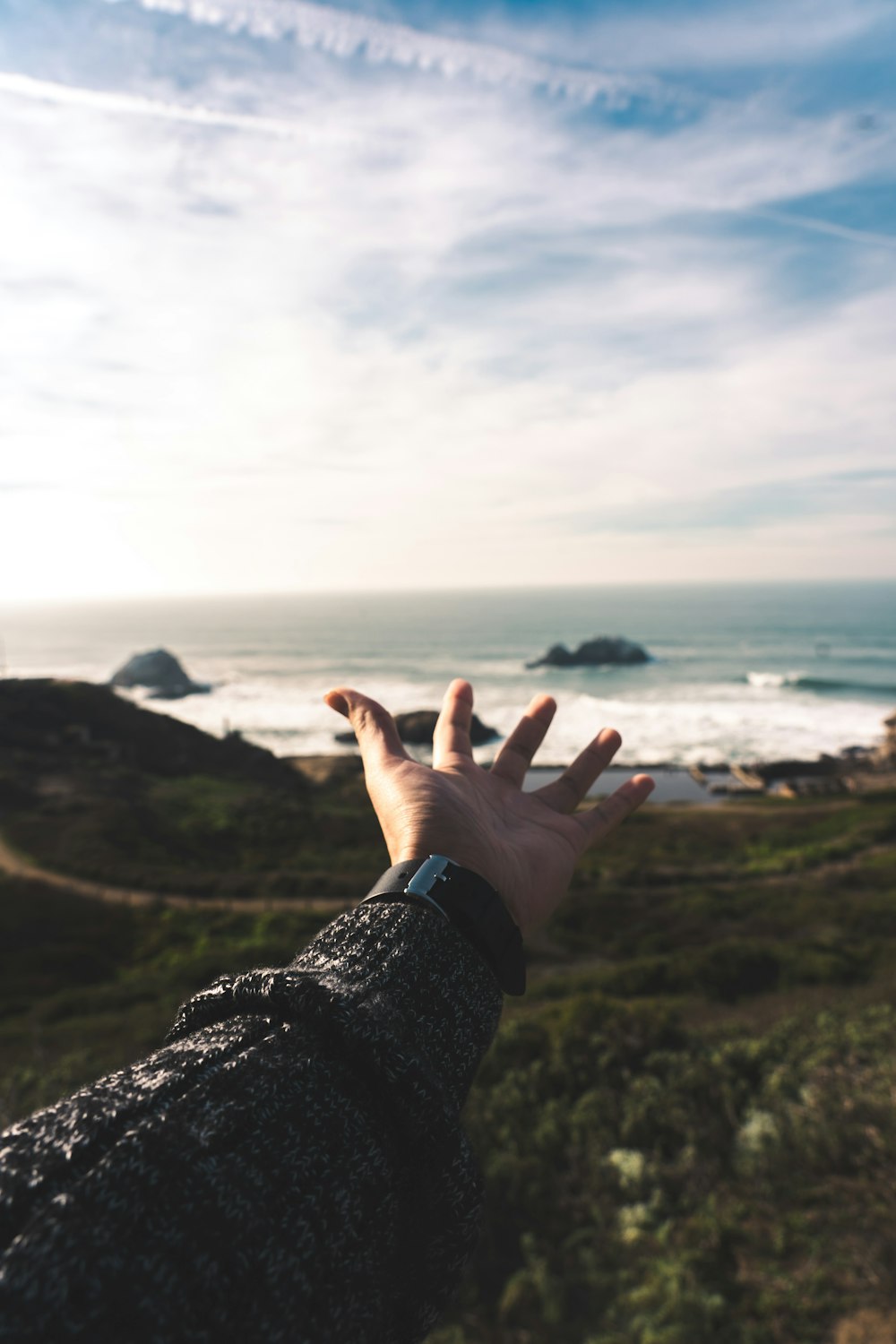 person in black long sleeve shirt raising left hand