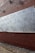 A partially constructed brick wall with layers of insulation boards attached to it. The insulation boards are marked with the brand 'Kingspan Kooltherm.' The bottom half of the wall is complete, while the top half is still under construction. The ground is covered in debris from the construction process.